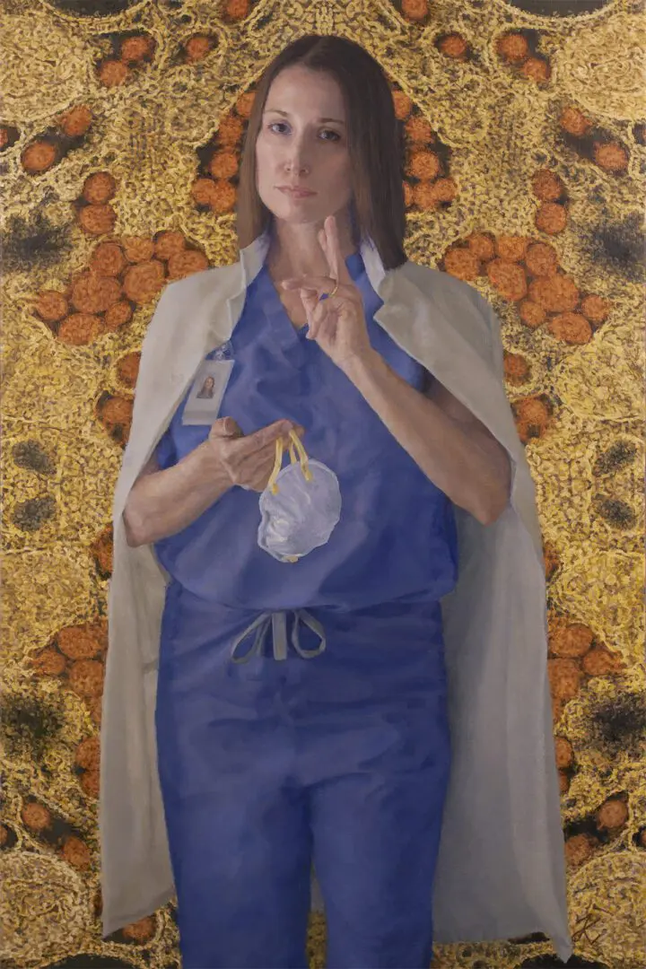 A woman in scrubs is holding something on her hand.