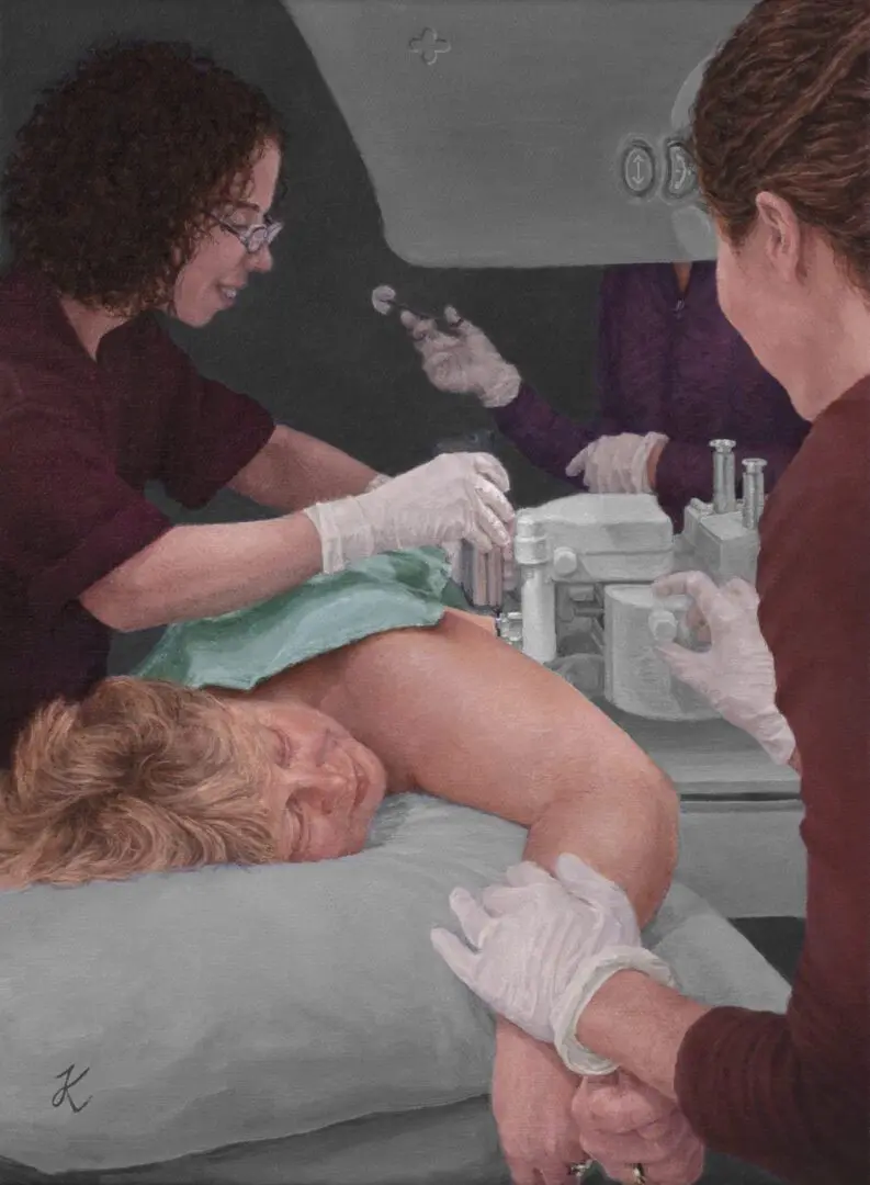 A woman is getting her breast waxed by two other women.