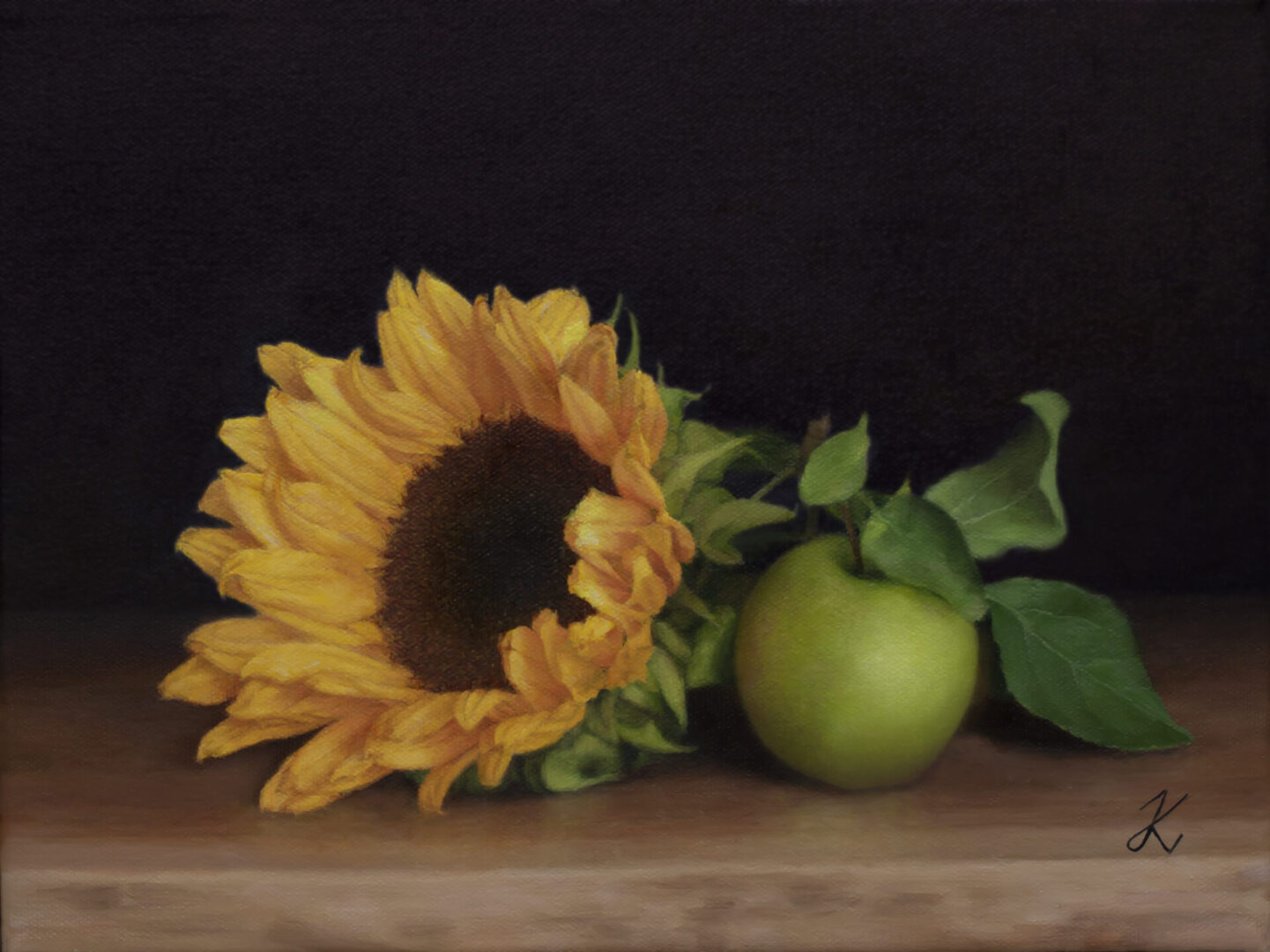 A sunflower and apple on a table.